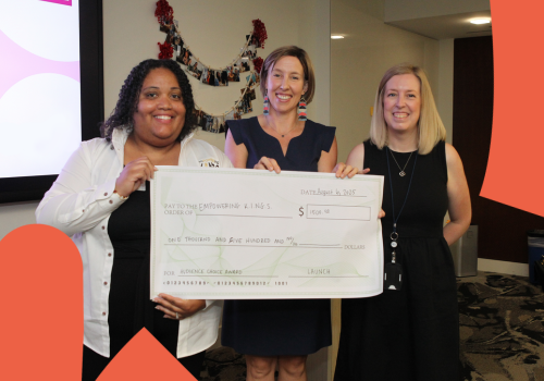 Three women holding a large check